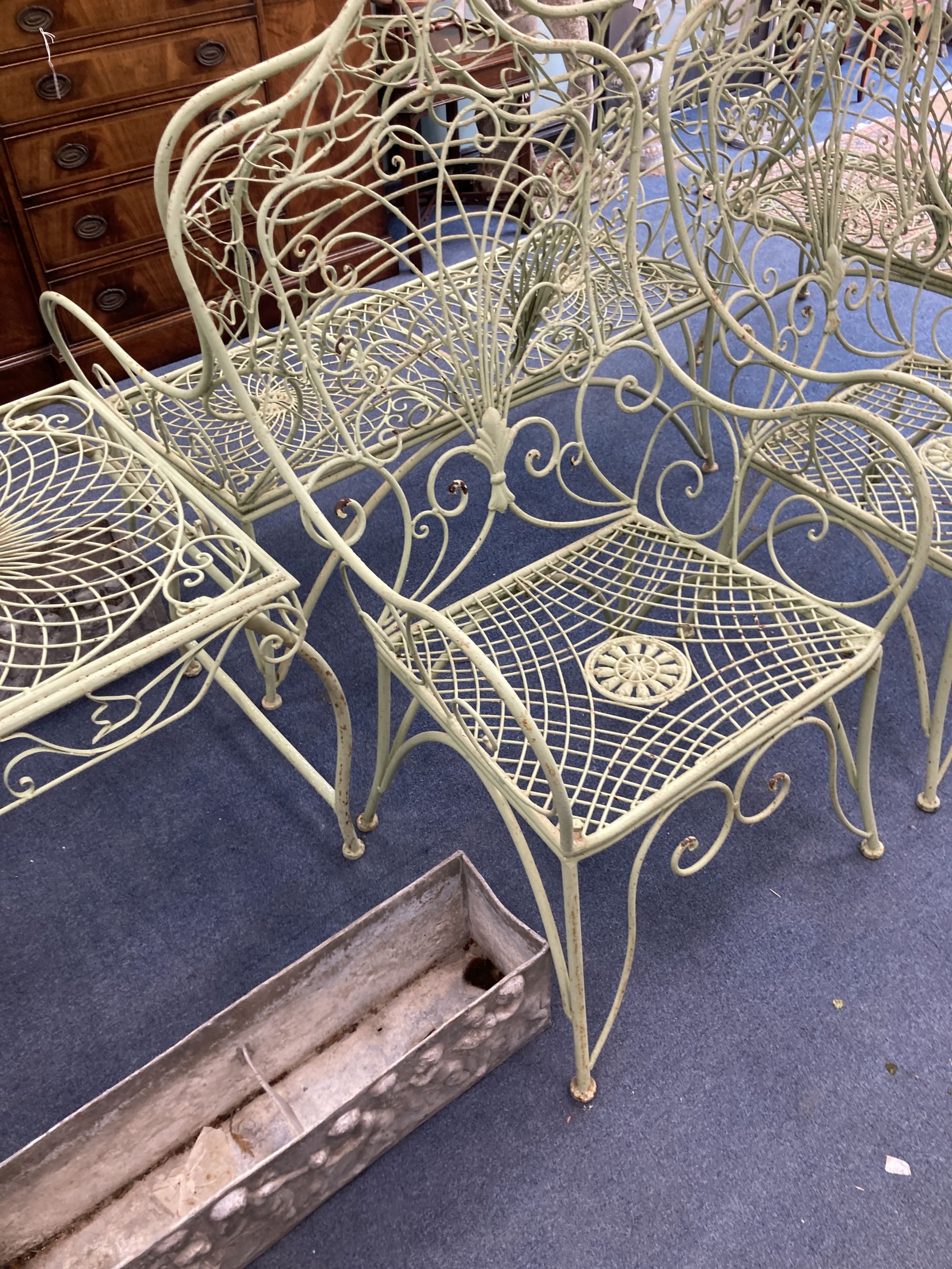 A French painted wrought iron garden suite comprising a pair of benches, length 122cm, depth 62cm, height 108cm, a pair of chairs and a table